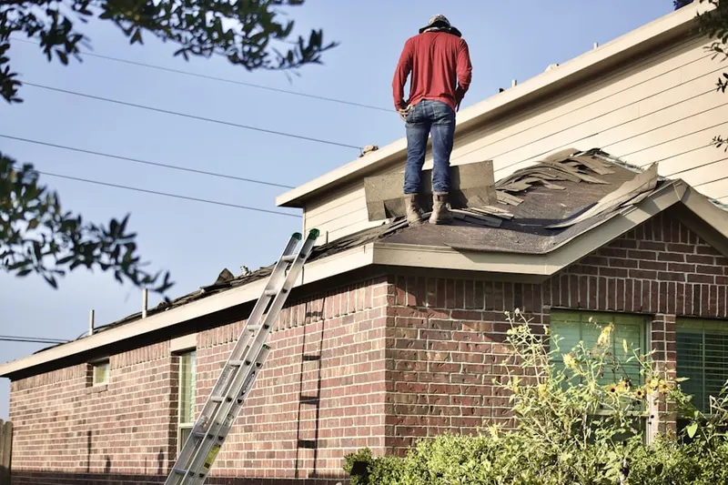Professional roofer working on a residential roof in School Park